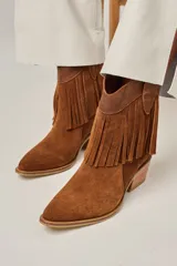 Bota tejana de cuero vacuno color beige con flecos en la caña, taco de 5.5 cm y caña de 17 cm.