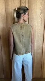 Chaleco color crudo con cuello redondo y detalle de costuras verticales en el frente.