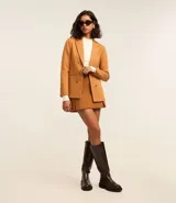 Blazer negro de punto roma con cuello solapa, cierre con ganchos, botones delanteros y forro de poliéster.