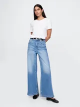 Pantalón de jean celeste de corte ancho, tiro alto y efecto degradado en el ruedo.