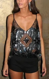 Blusa de tirantes finos confeccionada en tul negro con bordados florales y lentejuelas plateadas. Presenta un diseño con transparencias, escote en V y un patrón geométrico central.