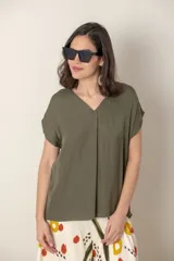 Blusa color verde militar de seda con escote en V y tabla en el frente. De manga corta y corte holgado. Talle único.