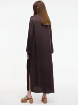 Vestido largo color crema, con cuello mao con lazo ajustable, mangas largas amplias y tajos laterales.