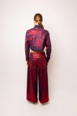 Pantalón jean largo tornasolado en tonos de bordo, rojo y azul. Diseño de pierna oversize con botones laterales que permiten usarlo abierto o cerrado.