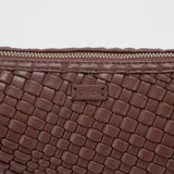 Bandolera negra de cuero trenzado con correa ajustable.