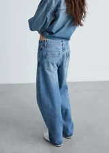 Pantalón de jean azul de corte amplio, tiro medio y cinco bolsillos.