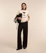 Remera de algodón color crema con cuello redondo y mangas cortas. Estampa frontal de una copa de Cosmopolitan y la inscripción "Cosmopolitan".