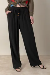 Pantalón ancho negro de lino y rayón, con cintura elastizada ajustable con cordón y bolsillos laterales.