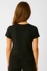 Remera negra de algodón con cuello en V, manga corta, corte holgado y estampado frontal con la frase "Life is not a race" en color naranja.