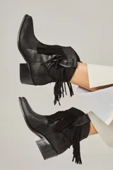 Bota tejana de cuero vacuno color beige con flecos en la caña, taco de 5.5 cm y caña de 17 cm.