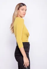 Remera color mostaza de manga larga con nudo en la parte frontal y textura acanalada.