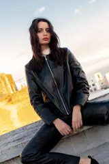 Chaqueta de cuero ovino color negro, con cierre frontal asimétrico y cuello mao.