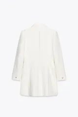 Blazer larga color blanco, de cuello solapa y manga larga con hombreras. Tiene bolsillos delanteros, forro interior y cierre frontal con botón metálico en relieve.