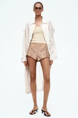 Musculosa de punto fino color beige, entallada, con escote en U en la parte delantera y trasera.