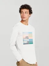 Camiseta blanca de manga larga con estampado rectangular con imagen de playa y edificio.