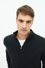 Campera tejida negra con cuello levemente elevado, cierre entero, logo bordado y fit regular.