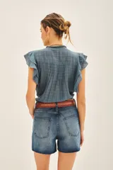 Camisa color crema de corte corto con escote redondo, mangas cortas con volados y jareta ajustable en el ruedo.