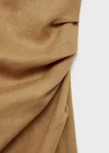 Vestido midi color ocre de lino, con corte asimétrico, un hombro descubierto, manga corta y cintura drapeada.