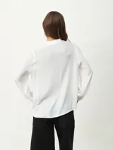Blusa celeste con cuello mao y escote en V, de mangas largas con puños elásticos.