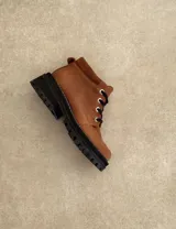 Borcego marrón de cuero con cordones, caña baja y suela track.