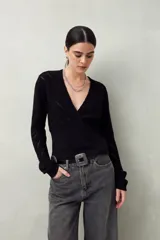 Sweater negro de tejido de punto calado, con escote en V cruzado y mangas largas.