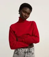 Blusa de punto color blanco, con cuello alto, manga larga y diseño liso.