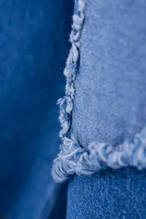 Pantalón de jean azul con parches en forma de estrella de un tono más claro y bordes desflecados.