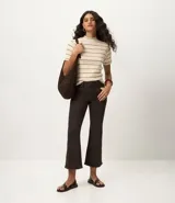 Blusa de ribana color beige con rayas horizontales negras, cuello medio y mangas cortas.