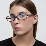 Montura de lentes para computadora con filtro de luz azul, de forma ovalada y montura gruesa con patrón carey (tortoise). Las patillas son de color blanco translúcido en la parte superior y carey en la parte inferior.