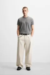 Pantalón de jean color crudo, corte relaxed fit, con bolsillos frontales y traseros tipo parche. Tiene tira multifunción y bolsillo tipo parche en las piernas.