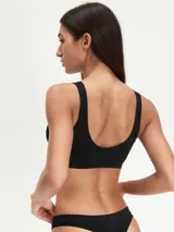 Top deportivo negro sin costuras, con breteles anchos y escote redondo.