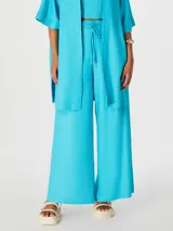 Pantalón celeste de corte palazzo con cintura elastizada y cordón ajustable.