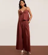 Pantalón de sastrería color terracota, modelo wide leg, con cintura con trabillas y detalle de hebilla lateral. Presenta cierre tradicional y bolsillos tipo cuchillo.