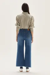Jean de mujer, tiro alto, corte ancho (wide leg) y largo hasta el tobillo con terminación deshilachada. Color azul medio.