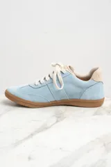 Zapatillas bajas de gamuza celeste con cordones blancos y suela de goma marrón.