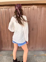 Camisa blanca de manga larga con detalle de bolitas en la tela.