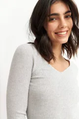 Sweater de punto color borgoña, con escote corazón y mangas largas.