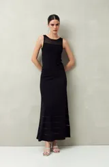 Falda larga negra de punto con silueta al cuerpo y leve evasé. Presenta transparencias lineales en el ruedo.