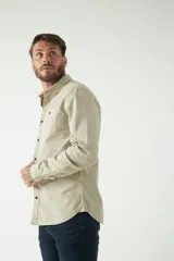 Camisa de hombre color marrón claro, de manga larga, con dos bolsillos frontales con botón y efecto stone wash.