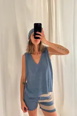 Chaleco tejido artesanalmente en hilado celeste, con cuello en V y sin mangas.