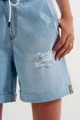 Short de jean celeste con cintura elastizada, cordón de ajuste y roturas.