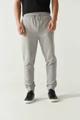 Pantalón de jogging gris con puños y logo estampado.