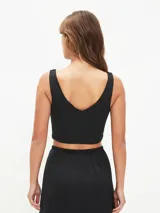 Top negro ajustado al cuerpo con escote en V profundo y tirantes anchos.