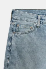 Jeans de tiro bajo, corte recto y largo completo, con efecto lavado y detalles de rotos en el delantero. Cierre frontal con cremallera y botón, y diseño de cinco bolsillos.