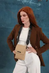 Bandolera tipo phone bag pequeña, color marrón claro, con correa de galón regulable. Tiene un compartimento principal y un bolsillo adicional con tapa.