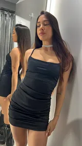 Vestido corto negro de satén con breteles finos y escote recto.