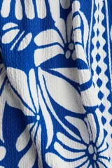 Vestido midi con estampado floral azul y blanco, breteles finos ajustables, escote cuadrado y cuerpo en punto smock.