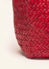 Bolso tipo tote de cuero vacuno, completamente trenzado a mano. El color es marrón oscuro, casi chocolate. Posee dos asas de hombro trenzadas.