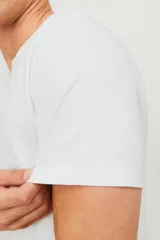 Camiseta de manga corta color blanco con cuello dividido y cierre de botón, fabricada en jersey de textura slub.