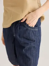 Bermuda color marrón claro, de tiro medio/alto, calce cómodo y relajado, con detalle de voladito en bolsillos.